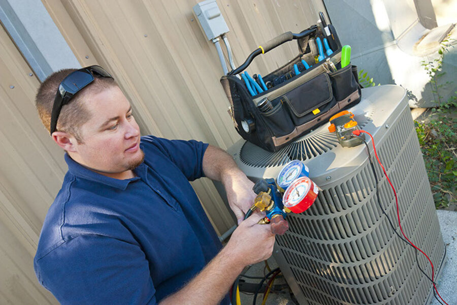 Technician servicing a residential AC unit
